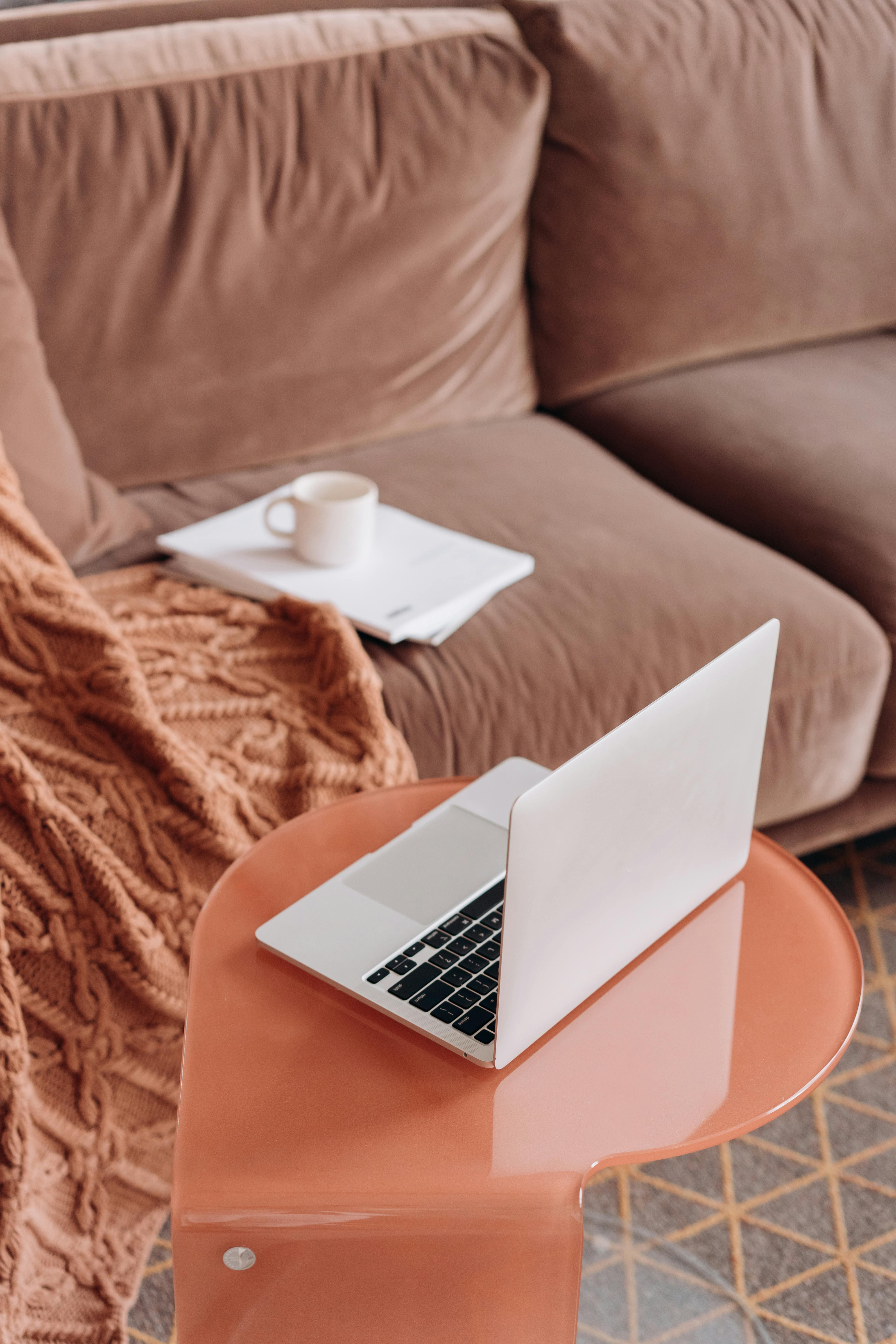 MacBook on a side table next to a couch